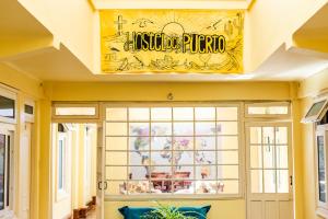 科金博Hostel Del Puerto的窗户上方墙上有标志的餐厅