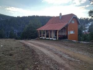 een klein huis op een onverharde weg in een veld bij Kuća za odmor Sofija in Divčibare