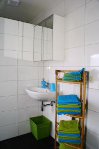 a bathroom with a sink and a shelf with towels at Bed and Breakfast de Meule Montfort in Montfort