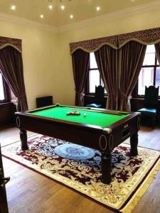 a living room with a pool table and curtains at Beautiful 4-Bed Villa in Glasgow in Glasgow
