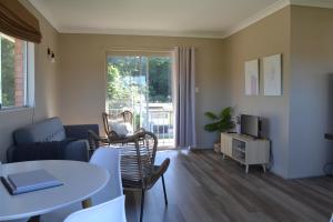 a living room with a table and chairs at Rio Rita Ocean View Apartments in Batemans Bay