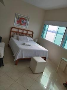 Un dormitorio con una cama grande y una ventana en Loft aconchegante, en São Vicente