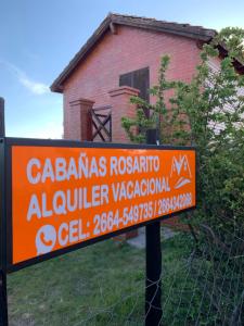 una señal naranja frente a una casa en Cabañas Rosarito en Villa Larca