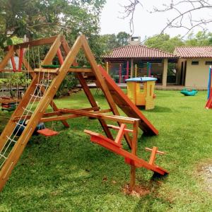 un juego de madera en un patio con parque infantil en Recanto Praia Azul, en Bombinhas