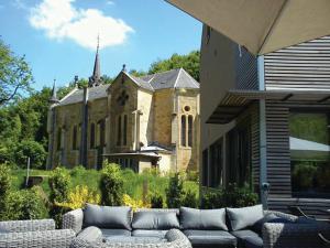 een oude kerk met een bank voor een gebouw bij Le Presbytère in Differdange