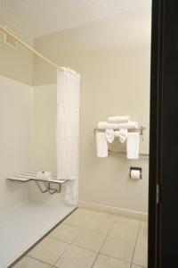 a bathroom with white towels and a shower curtain at Days Inn & Suites by Wyndham Airport Albuquerque in Albuquerque