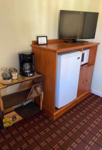 uma televisão em cima de um frigorífico num quarto em Monte Bianco Inn em Mount Shasta