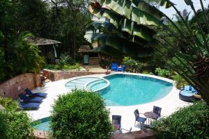 a swimming pool in a yard with chairs around it at Pousada Vila Serrano in Lençóis