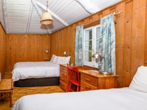 - une chambre avec 2 lits, un bureau et une fenêtre dans l'établissement Au Pic de l'Aurore Motel-Chalets, à Percé