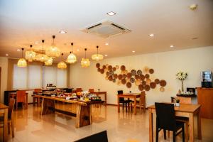 サント・ティルソにあるSanto Thyrso Hotelの木製のテーブルと椅子、シャンデリアが備わるレストラン