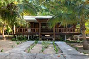ein Haus mit Palmen davor in der Unterkunft Luxurious Round Cay in Cayos Cochinos