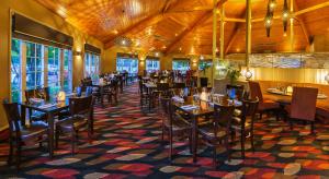 un ristorante con soffitti e tavoli in legno e sedie di Wairakei Resort Taupo a Taupo