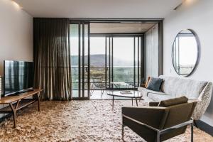 - un salon avec un canapé et une télévision dans l'établissement Nishi Apartments Eco Living by Ovolo, à Canberra