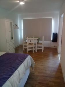 a bedroom with a bed and a table and chairs at Monoambiente Residencial in San Carlos de Bariloche