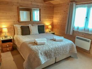 a bedroom with a bed with two towels on it at Pennylands Hill View Lodge in Broadway