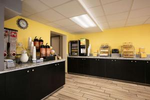 a kitchen with black cabinets and a yellow wall at Days Inn by Wyndham Clearwater/Central in Clearwater