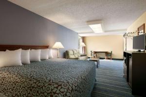 a hotel room with a bed and a chair at Days Inn by Wyndham Clearwater/Central in Clearwater