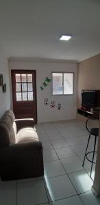 salon z kanapą i telewizorem w obiekcie Residencial Jardins w mieście Itamaracá