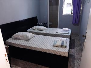 サンパウロにあるHotel Della Roseの小さな部屋のベッド2台(タオル付)