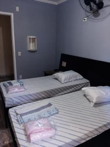 dos camas sentadas una al lado de la otra en una habitación en Hotel Della Rose, en São Paulo