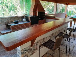 - un bar avec une cheminée dans une pièce avec des chaises dans l'établissement Recanto dos Passaros, à Socorro