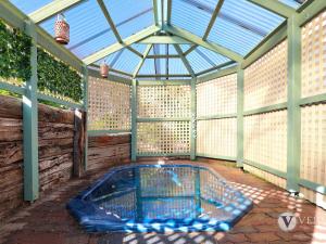 a hot tub in a greenhouse with a glass roof at Sea Ranch in Rye
