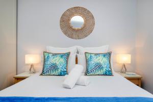a bedroom with a bed with two lamps and a mirror at Glenelg Oasis Studios in Adelaide +16 photos