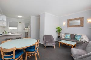 Adelaide的住宿－格萊內爾格綠洲公寓，客厅配有桌椅和沙发