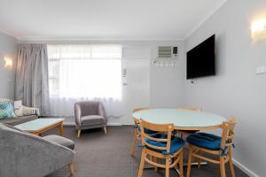 ein Wohnzimmer mit einem Tisch, Stühlen und einem Sofa in der Unterkunft Glenelg Oasis Studios in Adelaide
