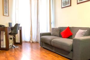 sala de estar con sofá gris y almohadas rojas en Departamentos Pontoni (Bellas Artes), en Santiago