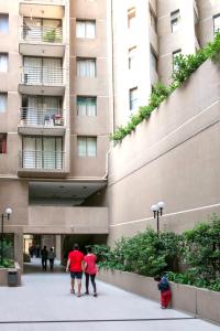 Un gruppo di persone che camminano davanti a un edificio di Departamentos Pontoni (Bellas Artes) a Santiago