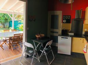 a kitchen with a table and chairs and a dining room at Habitation Baliache - Maison créole avec jardin privatif, plage à 200m in Deshaies