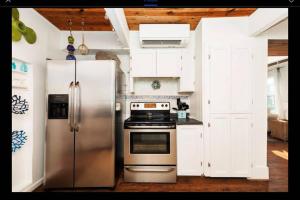 a kitchen with stainless steel appliances and white cabinets at Salty Poodle Cottage in Freeport