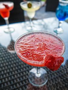 een rode drank in een martini glas op een tafel bij Liquid Dive Resort in Dauin