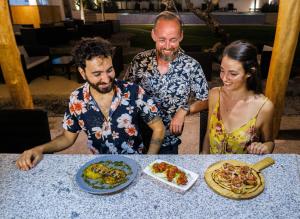 eine Gruppe von Menschen, die an einem Tisch mit Essen sitzen in der Unterkunft Liquid Dive Resort in Dauin