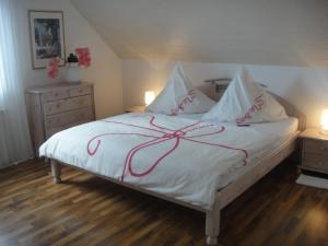 Schlafzimmer mit einem Bett mit roter Schrift in der Unterkunft Apartment Rose in Ahausen