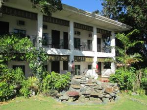 een groot wit gebouw met een stenen muur bij RedDoorz Plus @ Rio Grande de Laoag Resort Hotel Ilocos Norte in Laoag