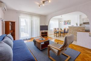 Apartments ALEX في كريكفينيسا: غرفة معيشة مع أريكة زرقاء وطاولة