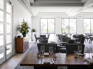 a restaurant with tables and chairs and windows at Hidden Valley Resort in Wallan