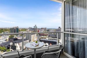 een balkon met een tafel en stoelen en uitzicht op de stad bij Quest Southbank in Melbourne