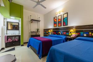 two beds in a room with green and blue at Hotel Calimera in Santa Teresita