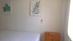 a bedroom with a bed and a dresser and two pictures at Casa Flamingos 25 in Ixtapa