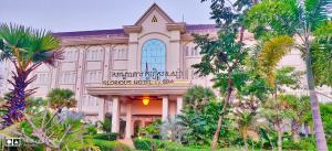 un edificio con palmeras delante en Glorious Hotel & Spa en Kompong Thom