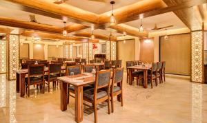 a dining room with wooden tables and chairs at Treebo Trend Opulence Inn in Udaipur