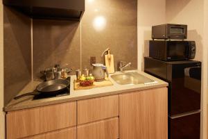 a small kitchen with a sink and a microwave at MONday Apart Premium 日本橋 in Tokyo