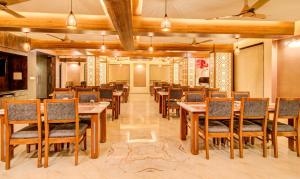 a dining room with wooden tables and chairs at Treebo Trend Opulence Inn in Udaipur