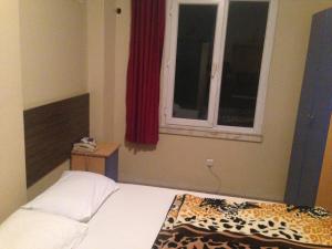 łóżko w pokoju z oknem i łóżko sidx sidx sidx w obiekcie Hotel Beyhan w mieście Mersin