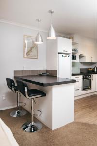 a kitchen with a black counter and white appliances at Fabulous Apartment with Private Spa Pool & Gym in Picton