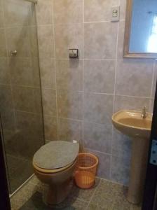 a bathroom with a toilet and a sink at Pousada Sro Adilson in Mangaratiba