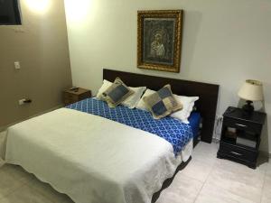 a bedroom with a large bed with blue and white sheets at Hermosa casa campestre CASARENA "un oasis en el llano" in Villavicencio